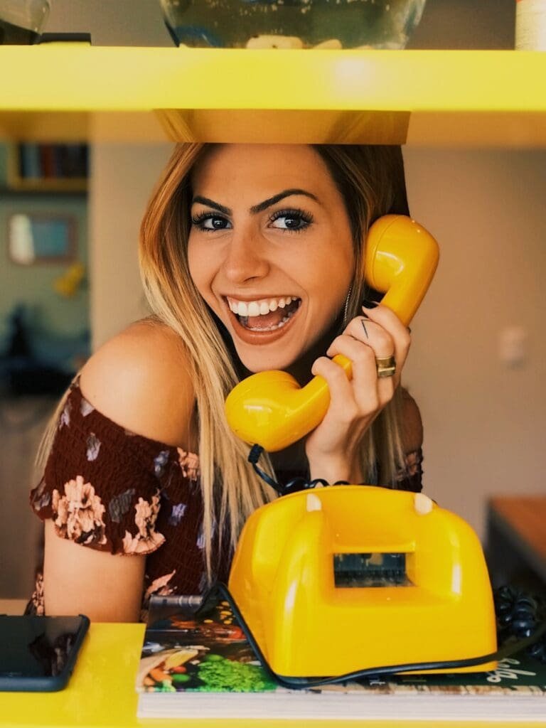Photo by Vinicius "amnx" Amano woman holding yellow rotary telephone